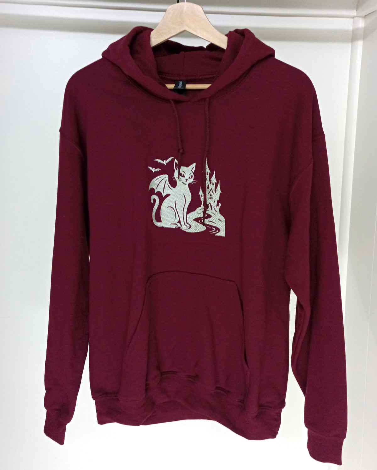 Le Château - Fil blanc sur sweat à capuche marron