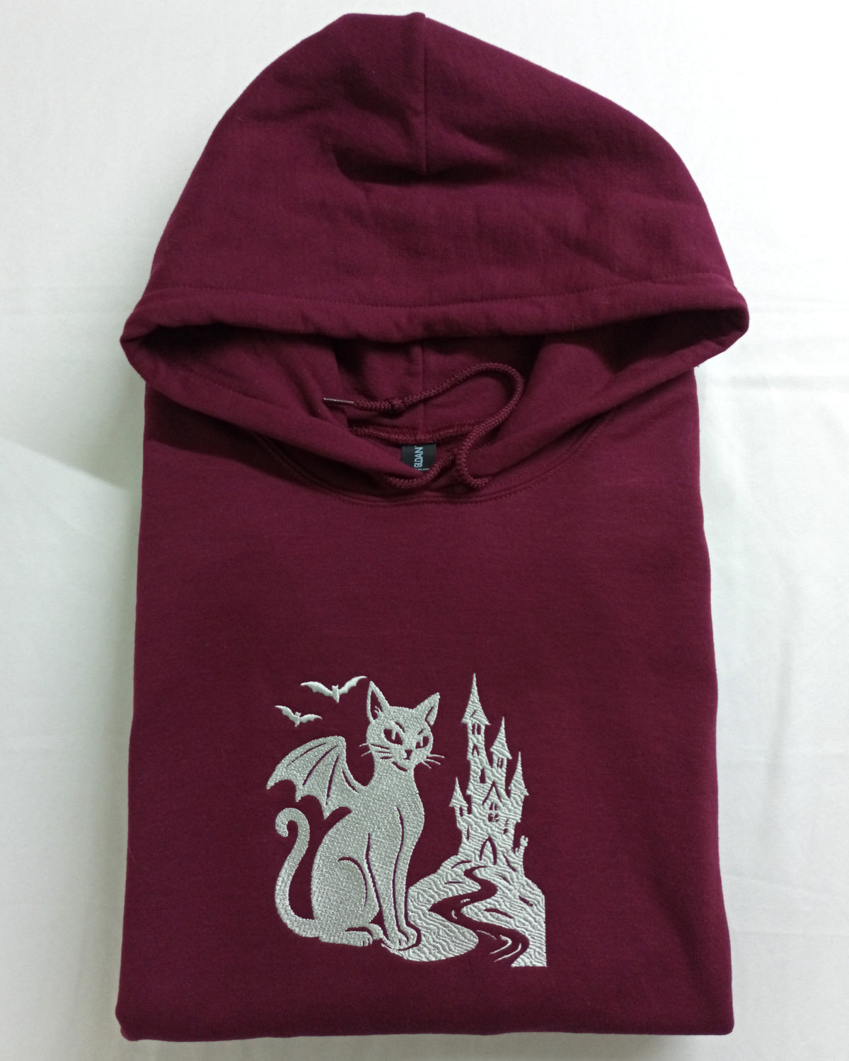Le Château - Fil blanc sur sweat à capuche marron