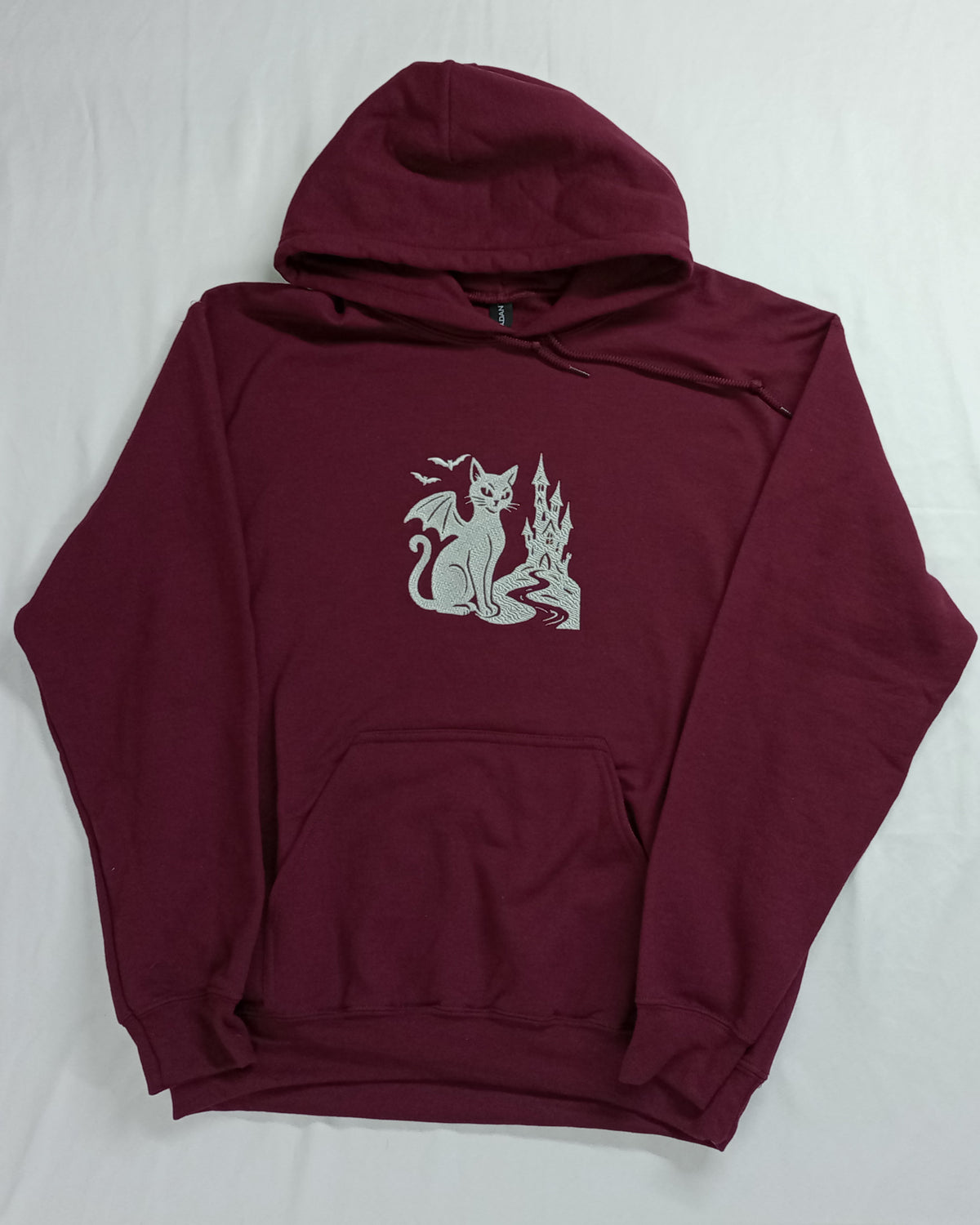 Le Château - Fil blanc sur sweat à capuche marron
