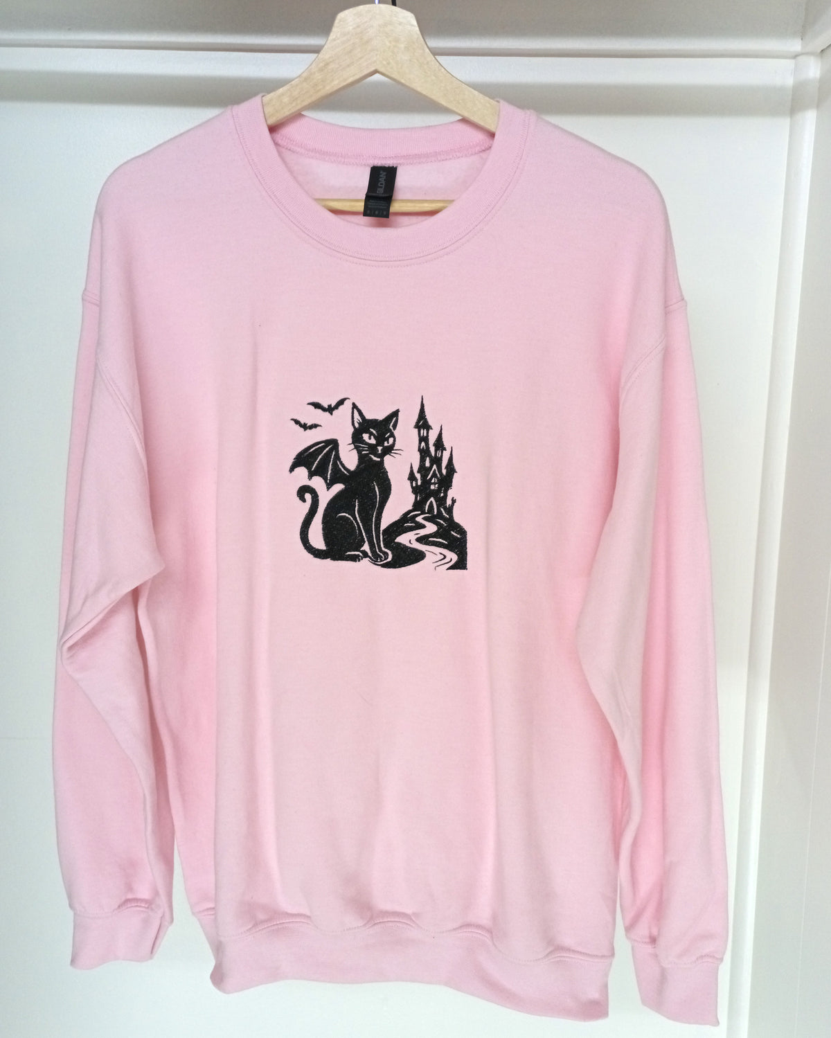 Le Château - Fil noir sur sweat à capuche rose clair