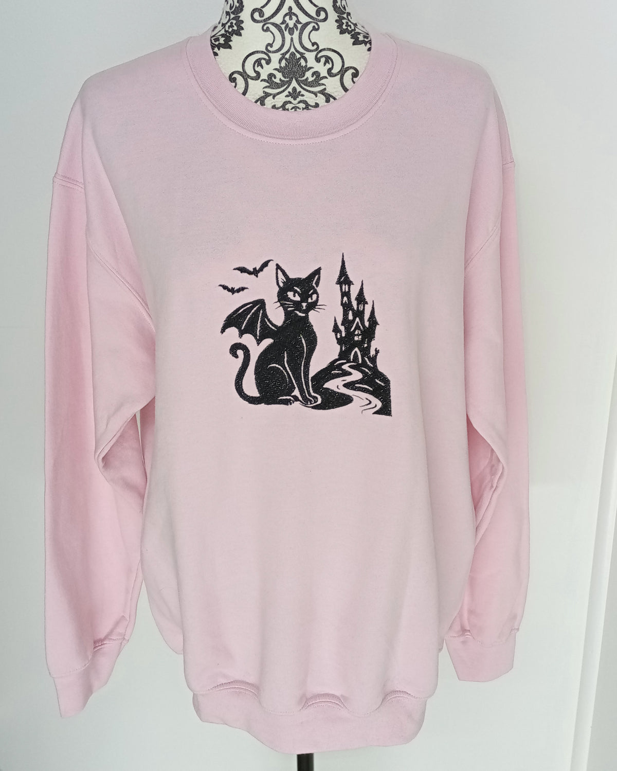 Le Château - Fil noir sur sweat à capuche rose clair