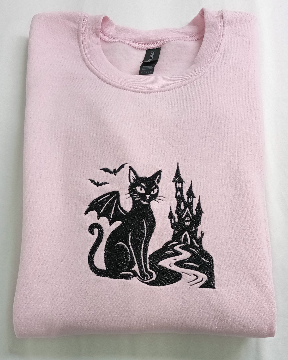 Le Château - Fil noir sur sweat à capuche rose clair