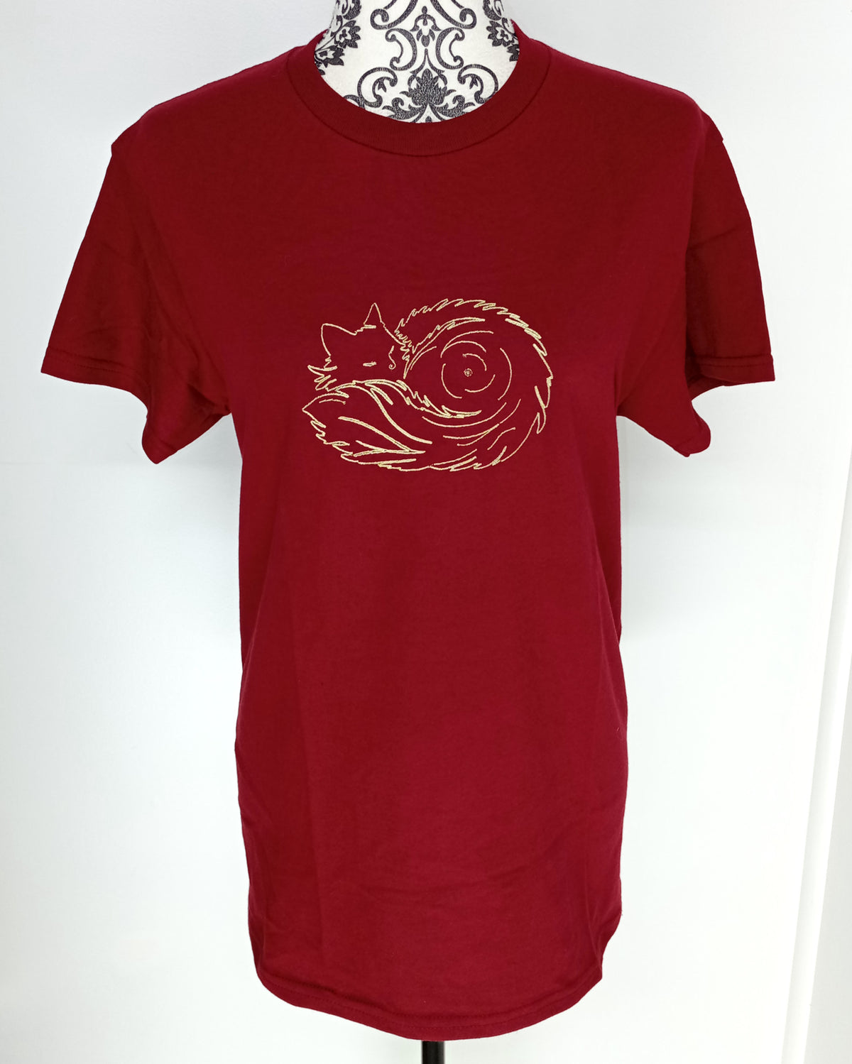 Pelote de poils - Fil doré brillant sur t-shirt rouge