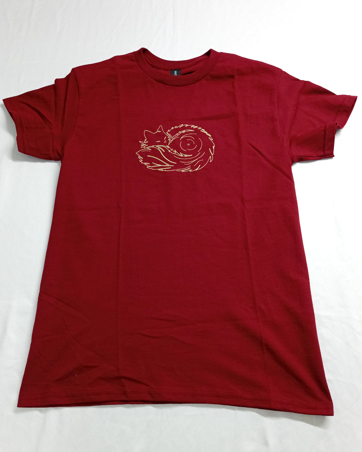 Pelote de poils - Fil doré brillant sur t-shirt rouge