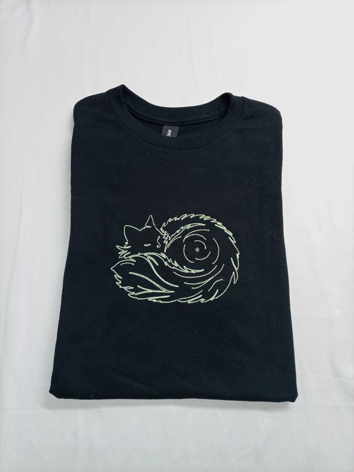 Pelote de poils - Fil phosphorescent sur t-shirt noir