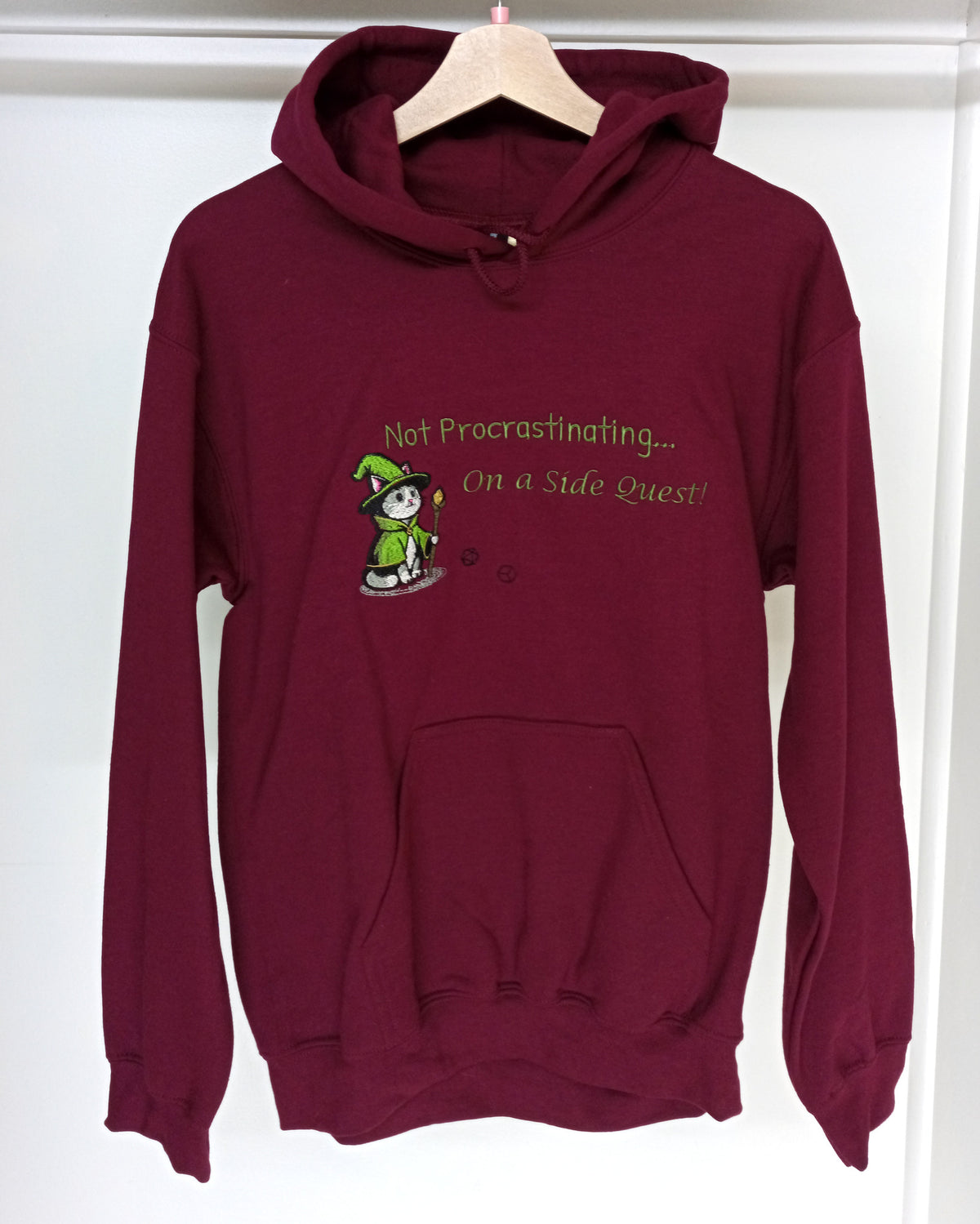 Quête secondaire - Sweat à capuche vert et blanc sur fond bordeaux