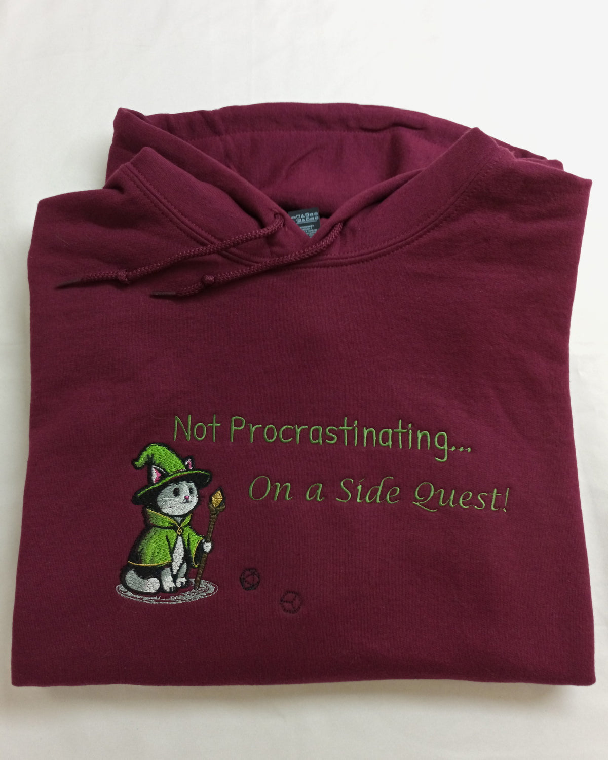 Quête secondaire - Sweat à capuche vert et blanc sur fond bordeaux